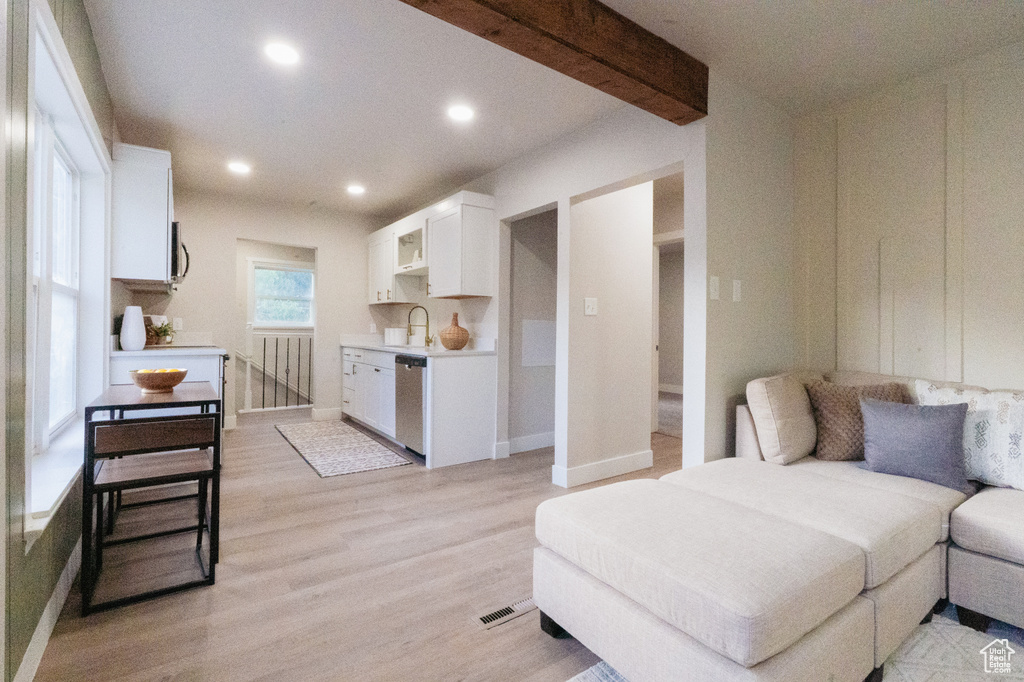 Living area with light wood-style floors and recessed lighting