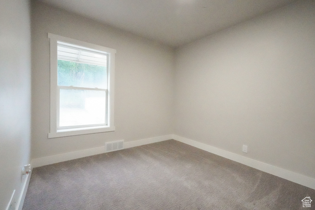 Carpeted empty room with baseboards