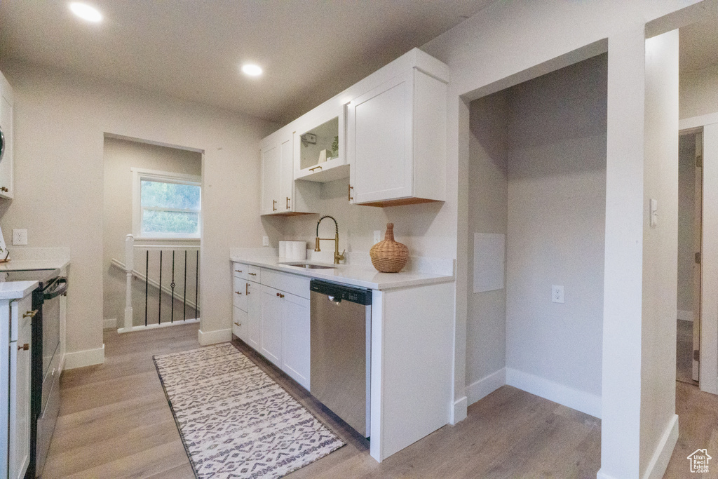 Kitchen featuring stainless steel dishwasher, electric range, light countertops, white cabinetry, and recessed lighting