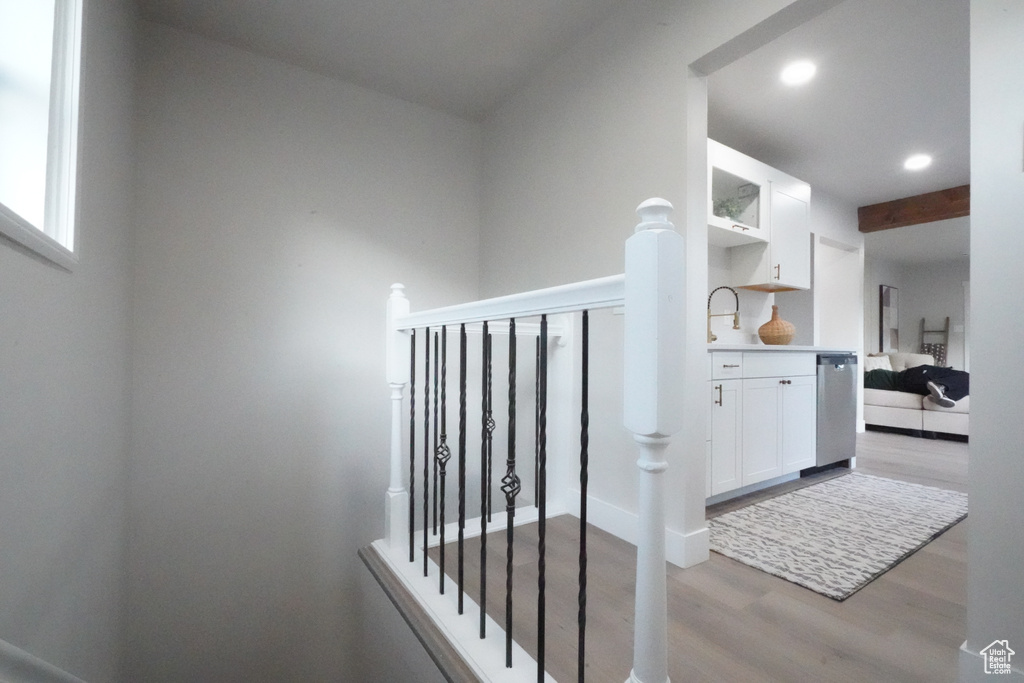 Stairway with wood finished floors and recessed lighting