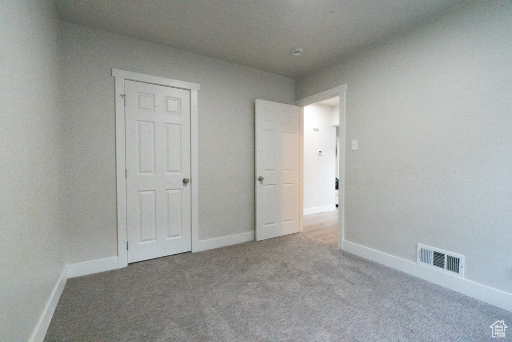 Unfurnished bedroom with carpet flooring and baseboards