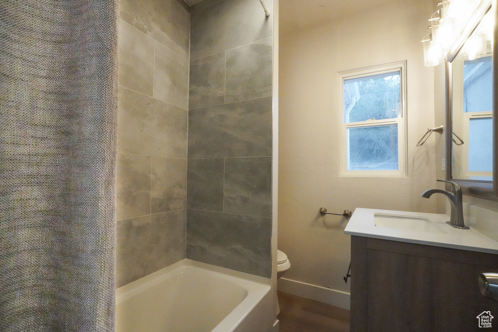 Full bathroom with vanity, shower / bath combination with curtain, and wood finished floors