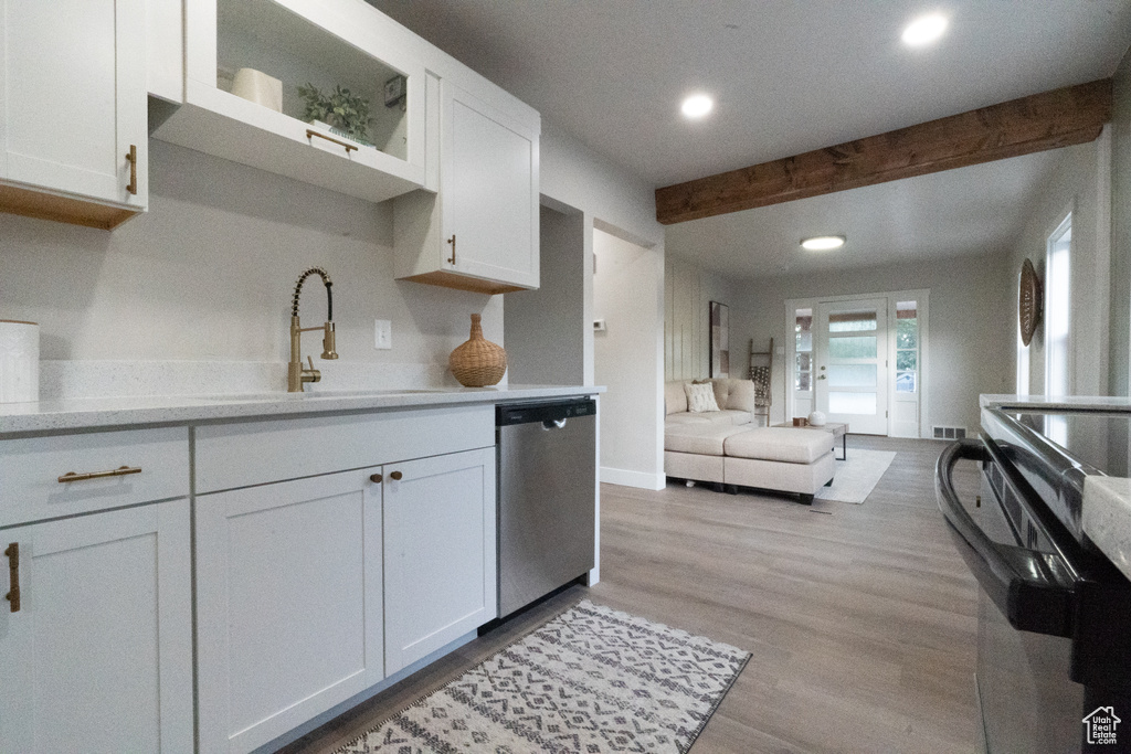 Kitchen with dishwasher, recessed lighting, beamed ceiling, white cabinets, and light wood-style flooring