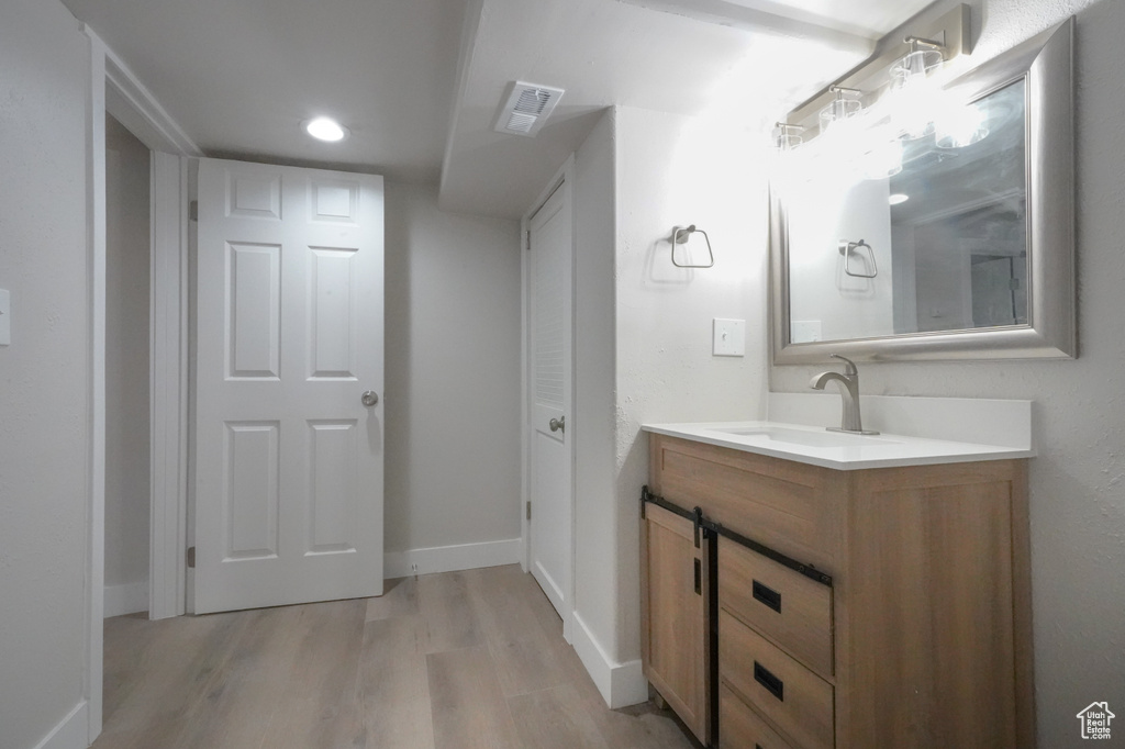 Bathroom featuring wood finished floors, vanity, and recessed lighting