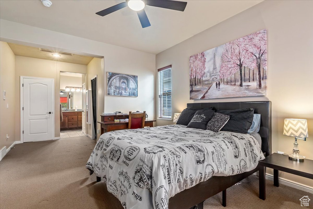 Bedroom with carpet floors, connected bathroom, and ceiling fan