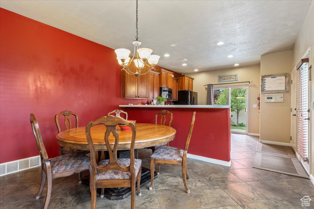 Dining space with a chandelier, recessed lighting, and a textured ceiling