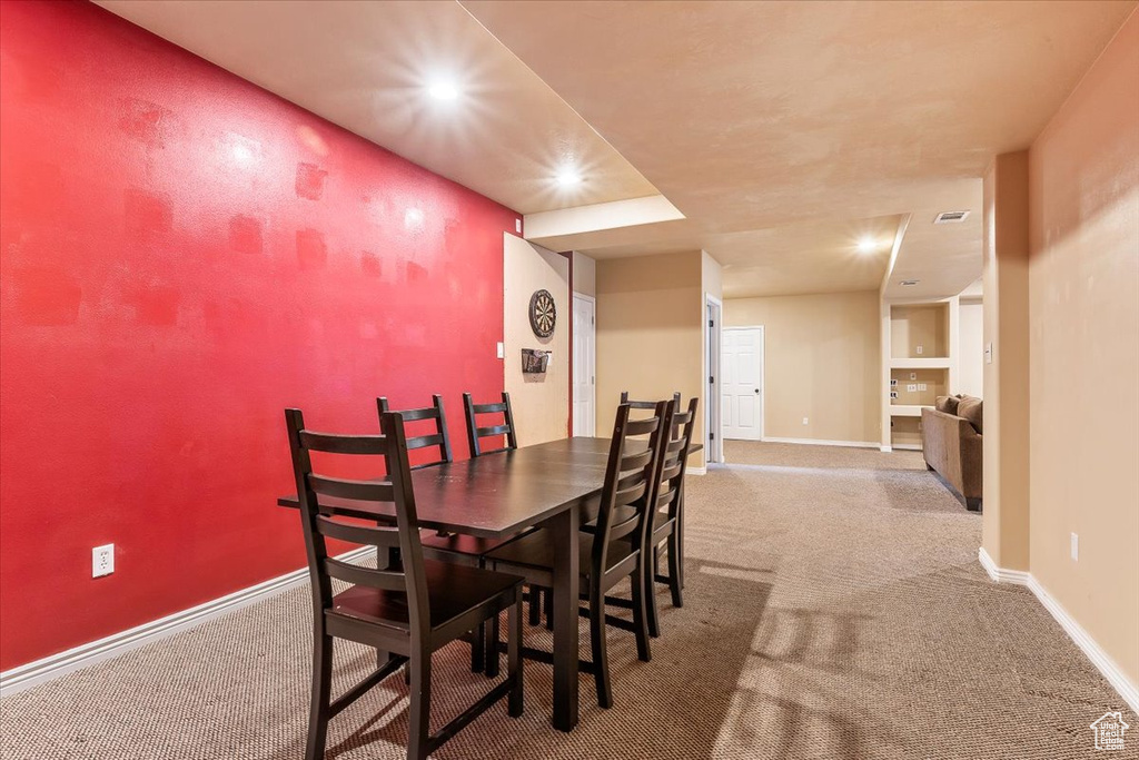 Carpeted dining area with baseboards and recessed lighting