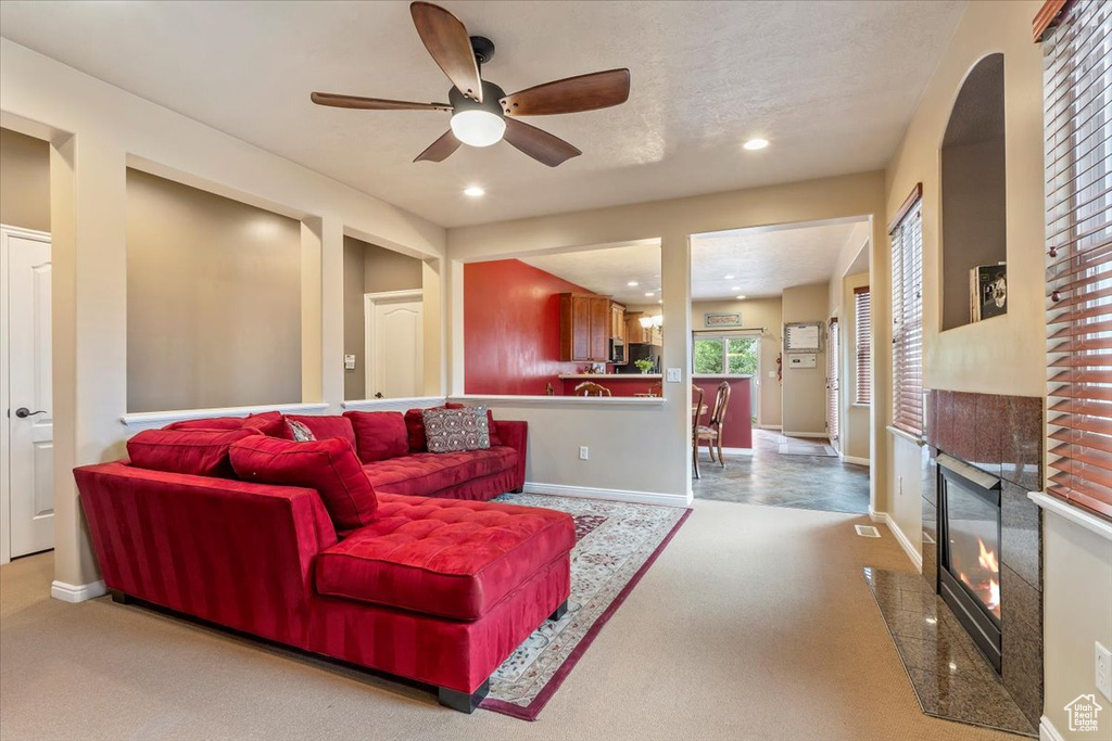 Carpeted living room featuring ceiling fan, a high end fireplace, and recessed lighting