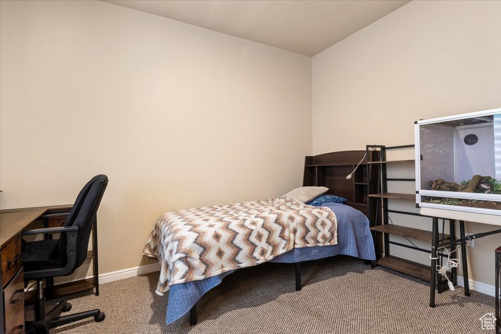 Carpeted bedroom featuring an office area and lofted ceiling