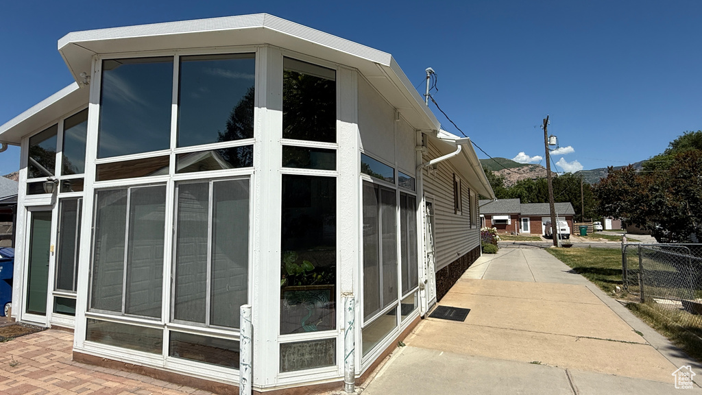 View of side of property with a sunroom