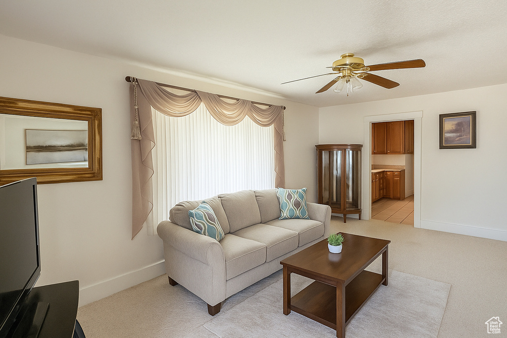 Living room with ceiling fan and light carpet
