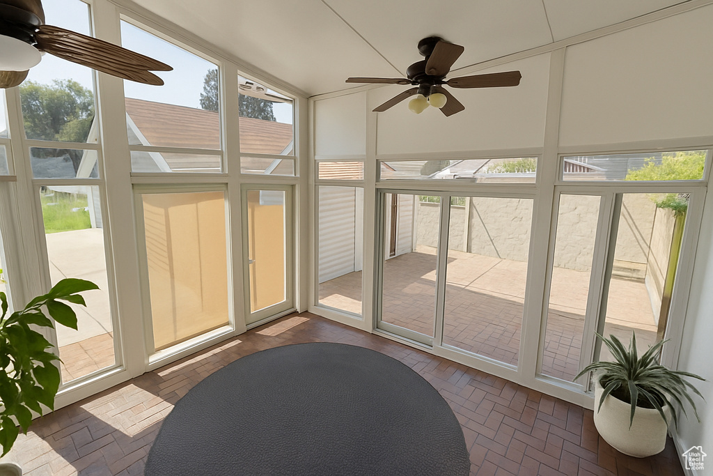 Sunroom featuring a ceiling fan and lofted ceiling