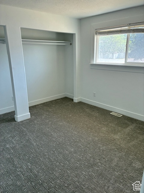 Unfurnished bedroom with carpet and a textured ceiling