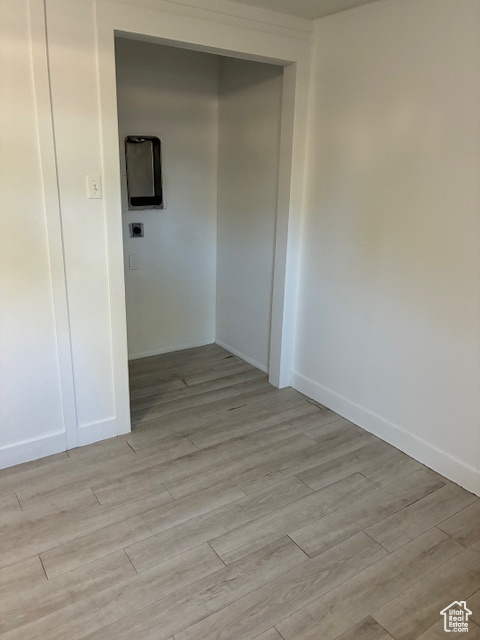 Spare room featuring light wood finished floors and baseboards