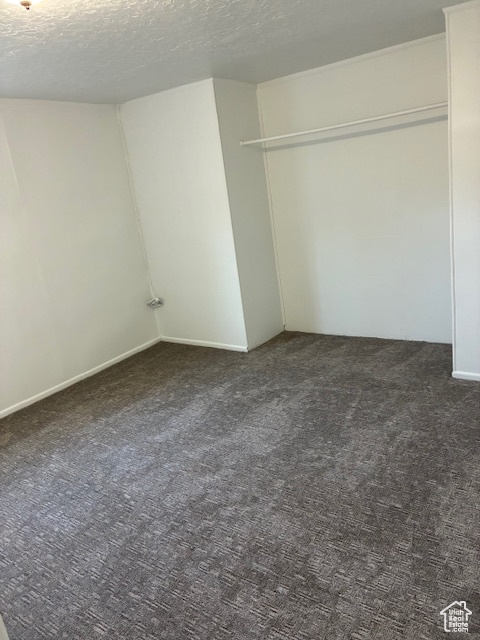 Unfurnished bedroom featuring carpet, a textured ceiling, and a closet