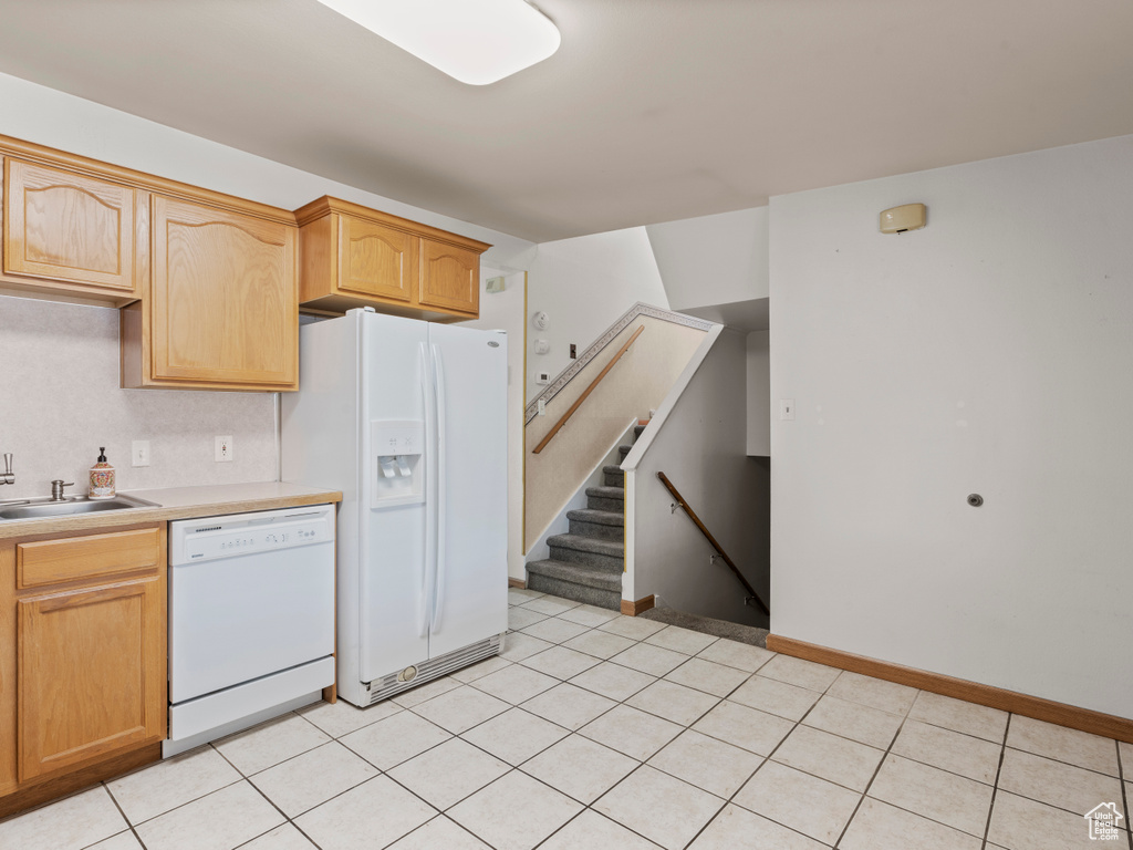 Kitchen featuring white appliances, light countertops, and light tile patterned floors