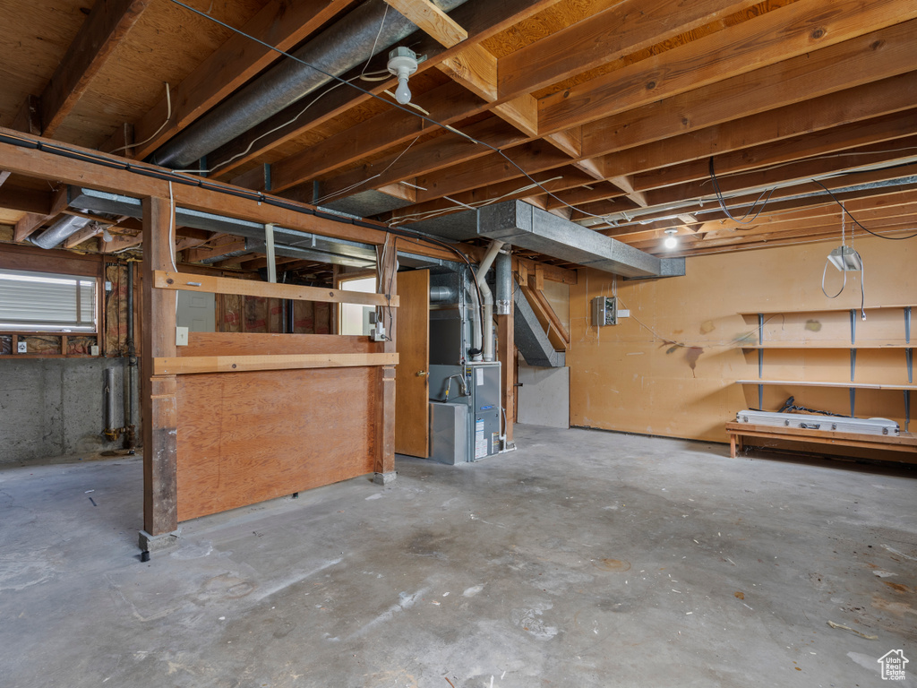 Unfinished below grade area featuring heating unit
