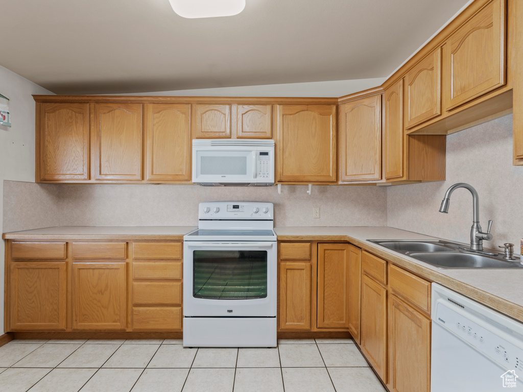 Kitchen with white appliances, light countertops, and light tile patterned floors