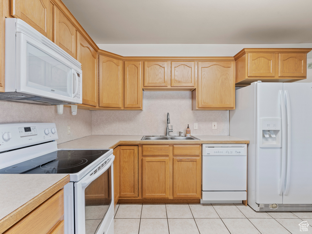 Kitchen with white appliances, light countertops, and light tile patterned floors