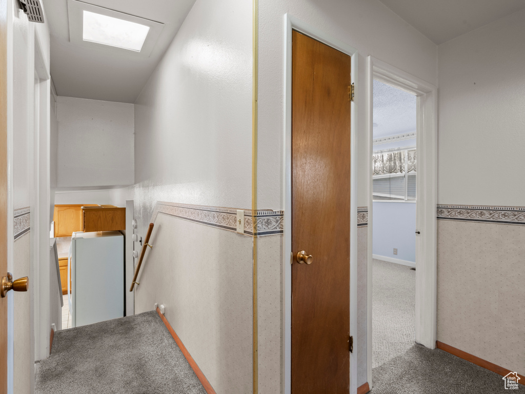 Hallway featuring an upstairs landing and carpet flooring