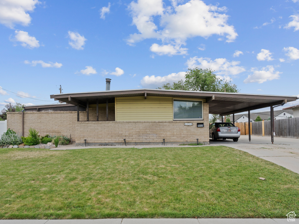 View of front of property featuring brick siding, a carport, and concrete driveway