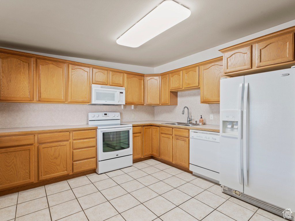 Kitchen featuring white appliances, light countertops, and light tile patterned flooring