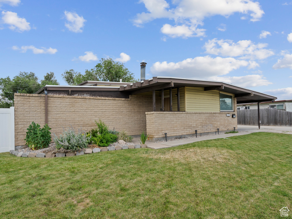 View of side of home featuring a carport and brick siding