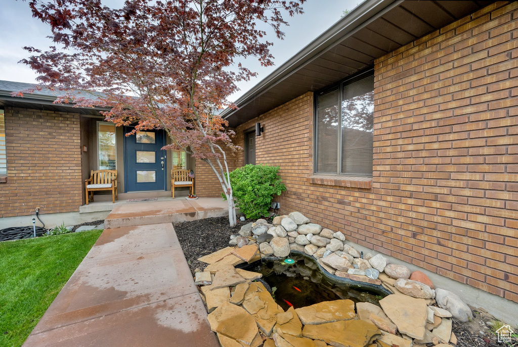 View of exterior entry featuring brick siding