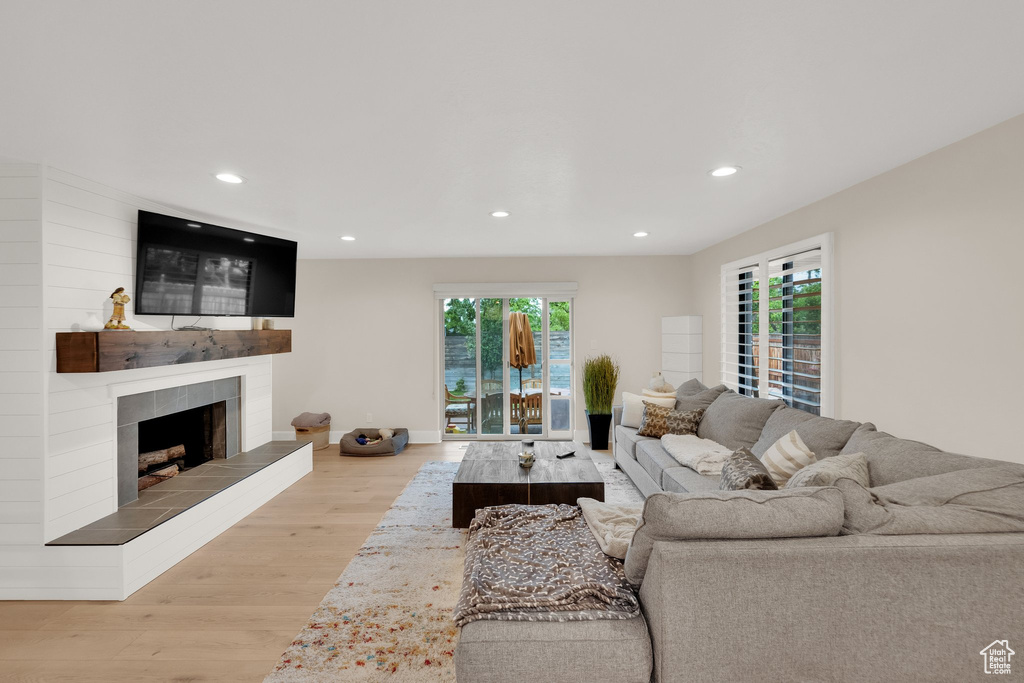 Living area featuring wood finished floors, recessed lighting, and a tiled fireplace