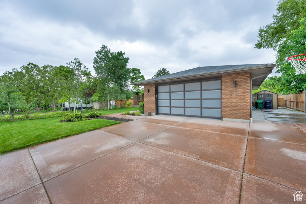 Garage with driveway and a shed