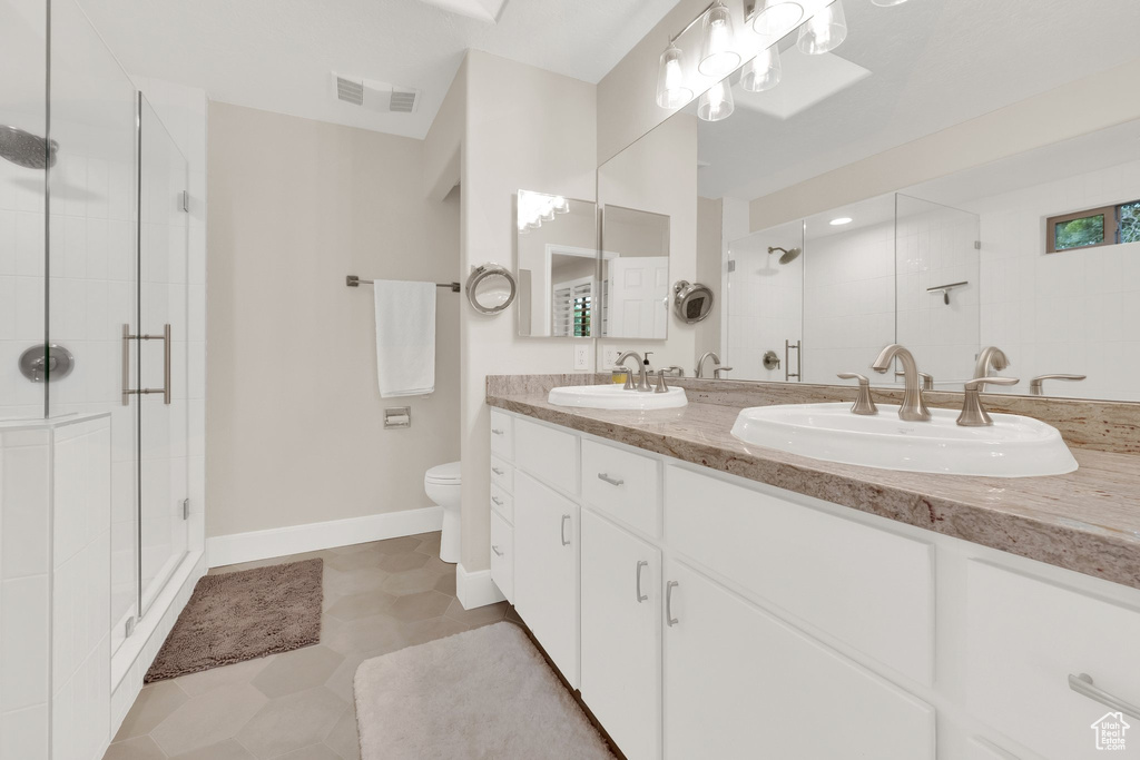 Bathroom featuring a stall shower and double vanity