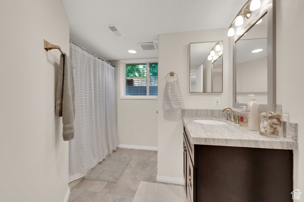 Bathroom with vanity and curtained shower