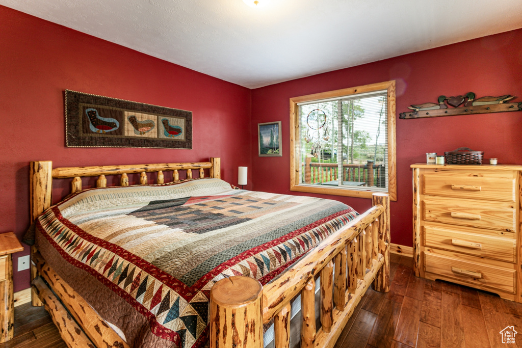 Bedroom with dark wood-style flooring and baseboards