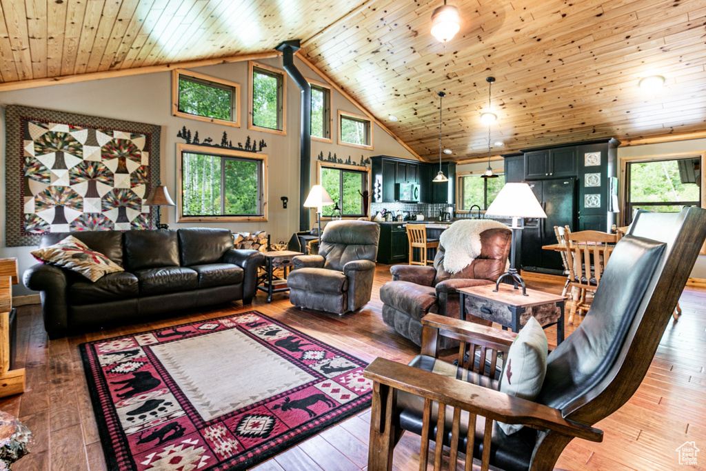 Living area with wooden ceiling, plenty of natural light, high vaulted ceiling, and light wood finished floors