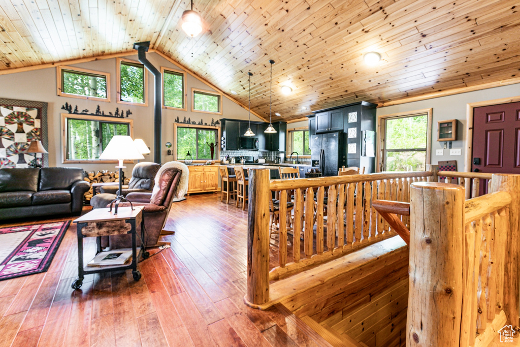 Living room featuring wooden ceiling, wood-type flooring, and high vaulted ceiling