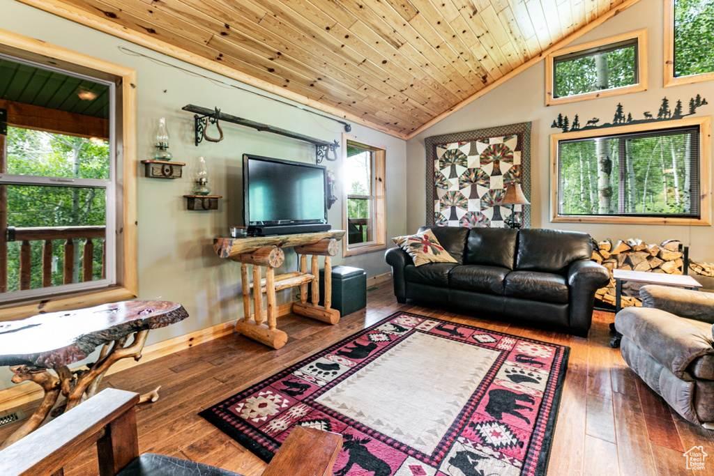 Living area featuring vaulted ceiling, hardwood / wood-style flooring, and wood ceiling