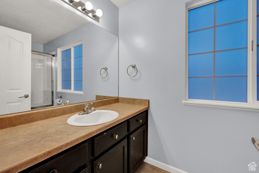 Bathroom with vanity and a shower with door
