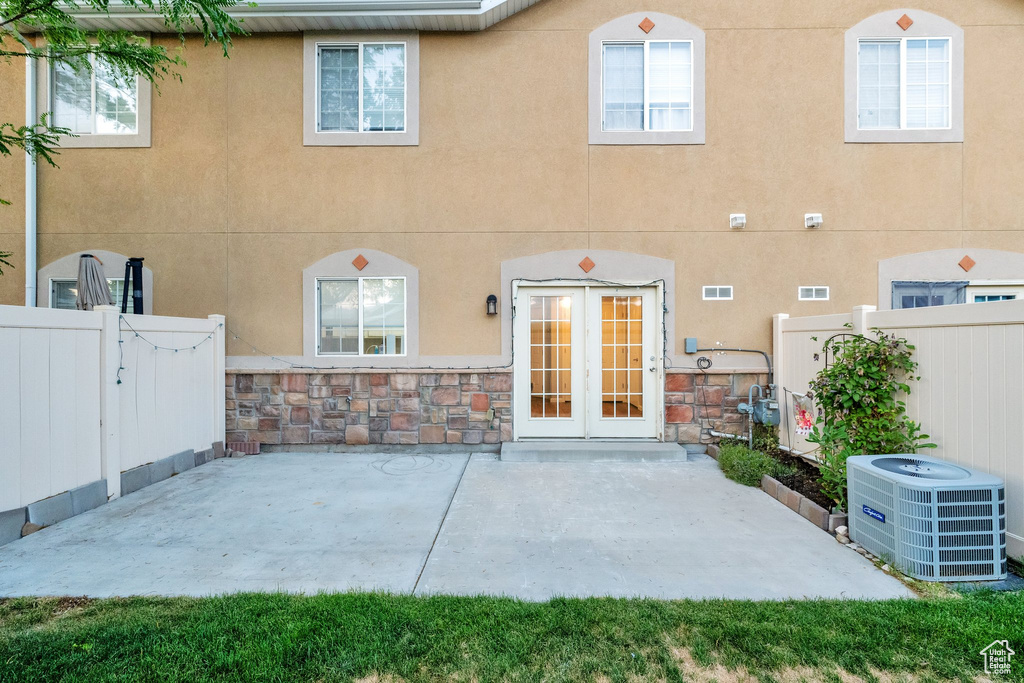 Back of property featuring a patio, stucco siding, and stone siding
