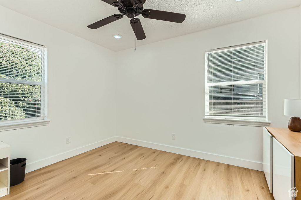 Unfurnished room with light wood-type flooring, a ceiling fan, and recessed lighting