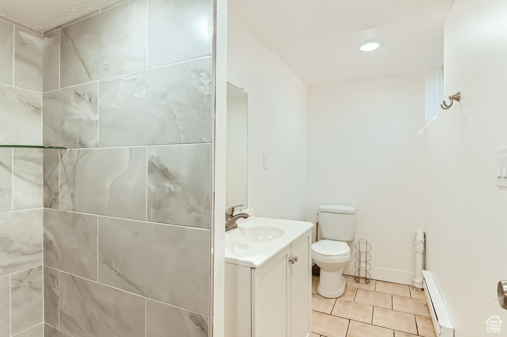 Bathroom featuring vanity, a baseboard heating unit, and tile patterned flooring