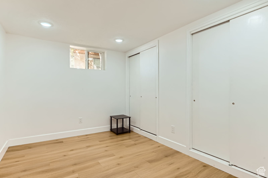 Unfurnished bedroom with light wood-style flooring, recessed lighting, and multiple closets