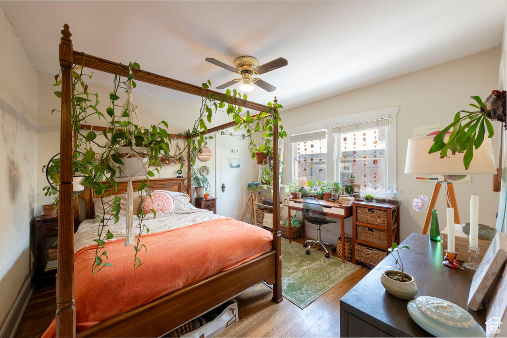 Bedroom with wood finished floors, a ceiling fan, and a desk