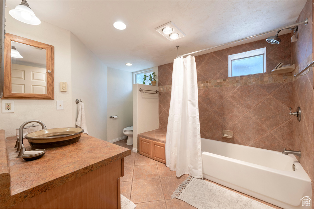 Full bathroom with plenty of natural light, vanity, shower / tub combo, tile patterned floors, and recessed lighting