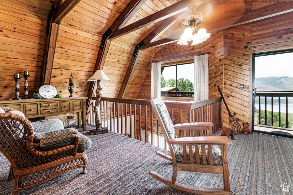 Living area with carpet floors, wooden ceiling, wooden walls, and a chandelier