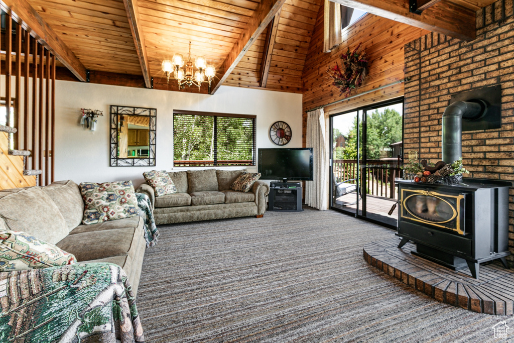 Carpeted living area with a wood stove, a chandelier, and a wood ceiling with exposed beams