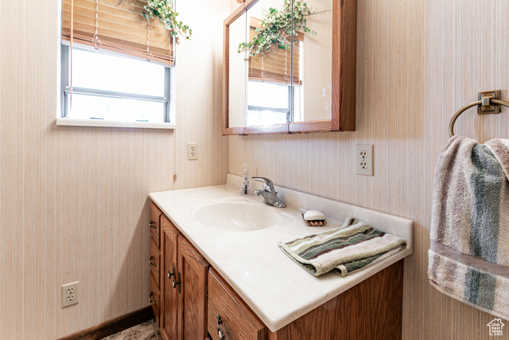 Bathroom with vanity and wallpapered walls