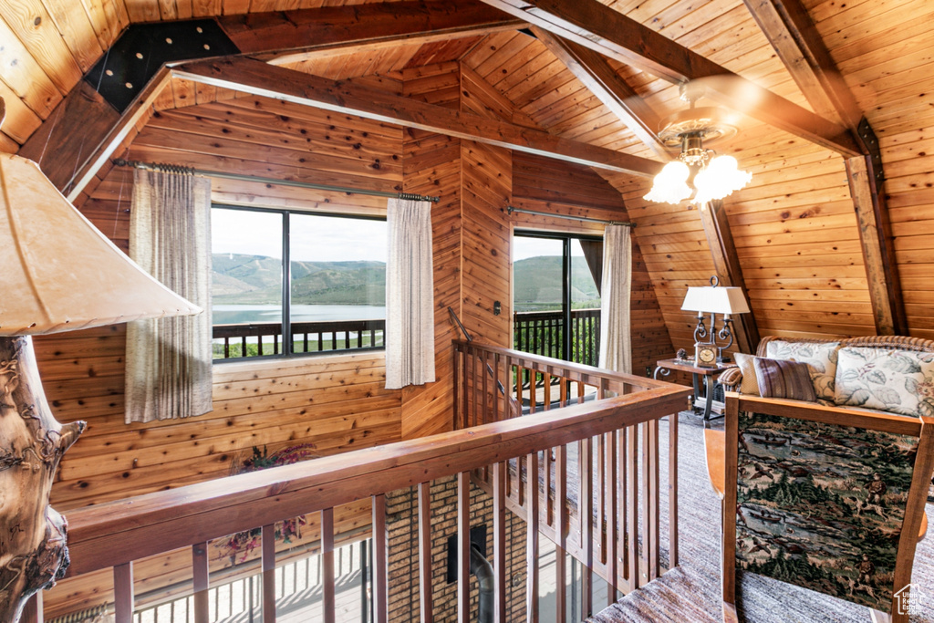Hallway featuring wooden ceiling, wood walls, a chandelier, and a water view