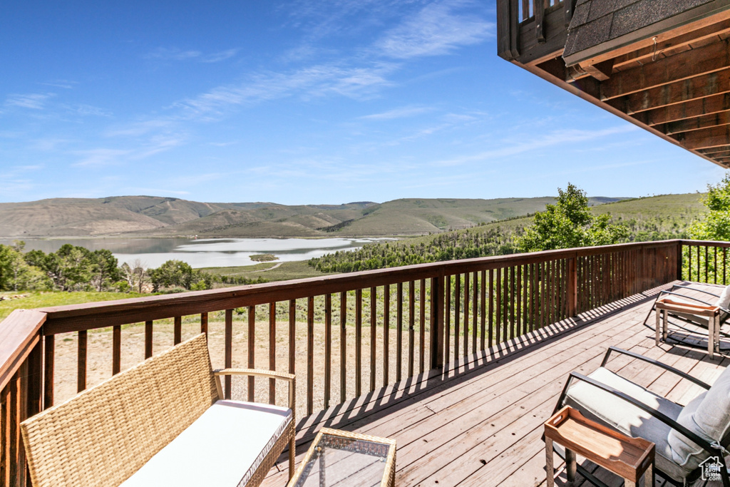 Wooden terrace featuring a water and mountain view
