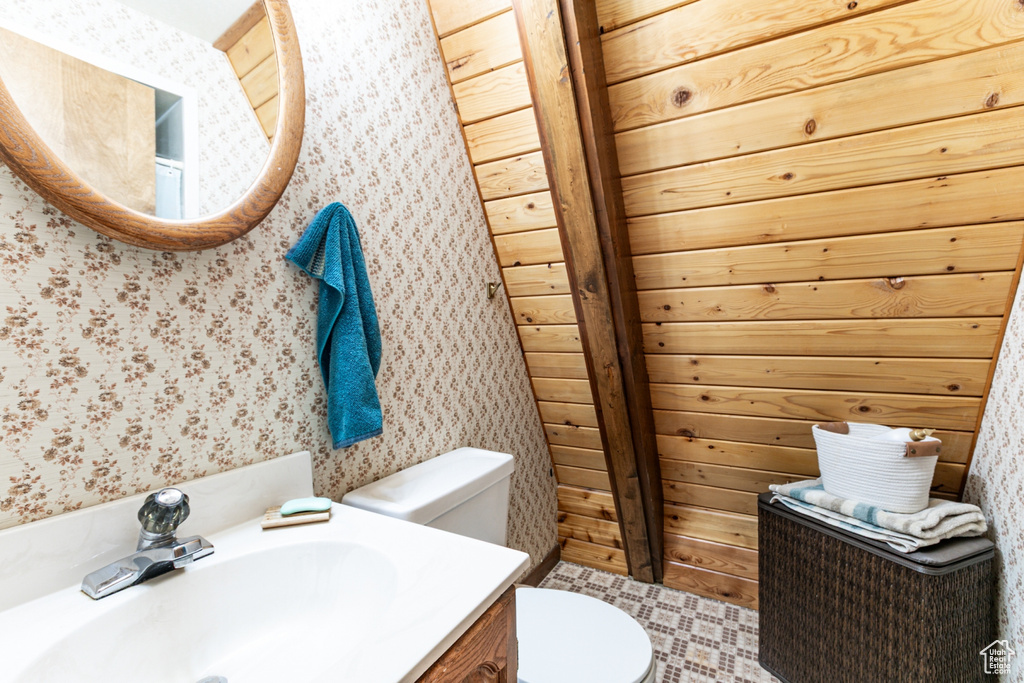 Bathroom with wallpapered walls and vanity