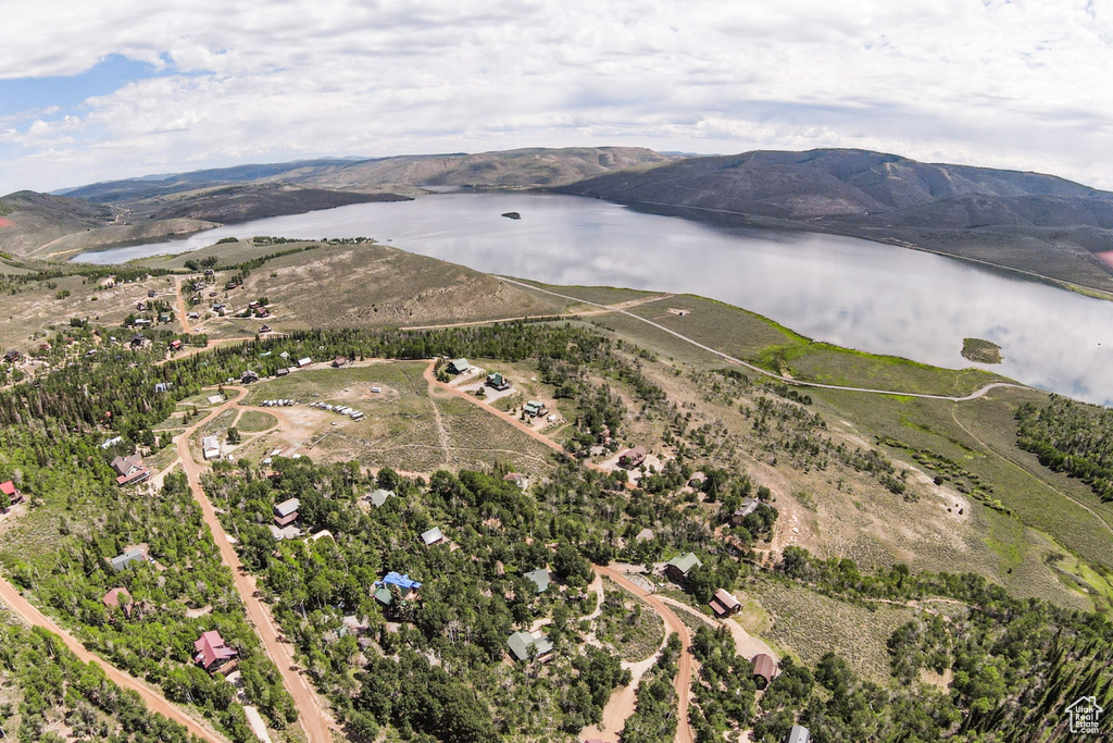 Aerial view of property and surrounding area with a water and mountain view